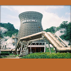 A geothermal power plant with piping and a orange background.
